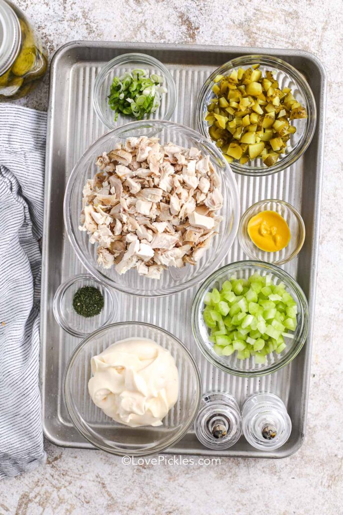 ingredients for dill pickle chicken salad on a baking sheet