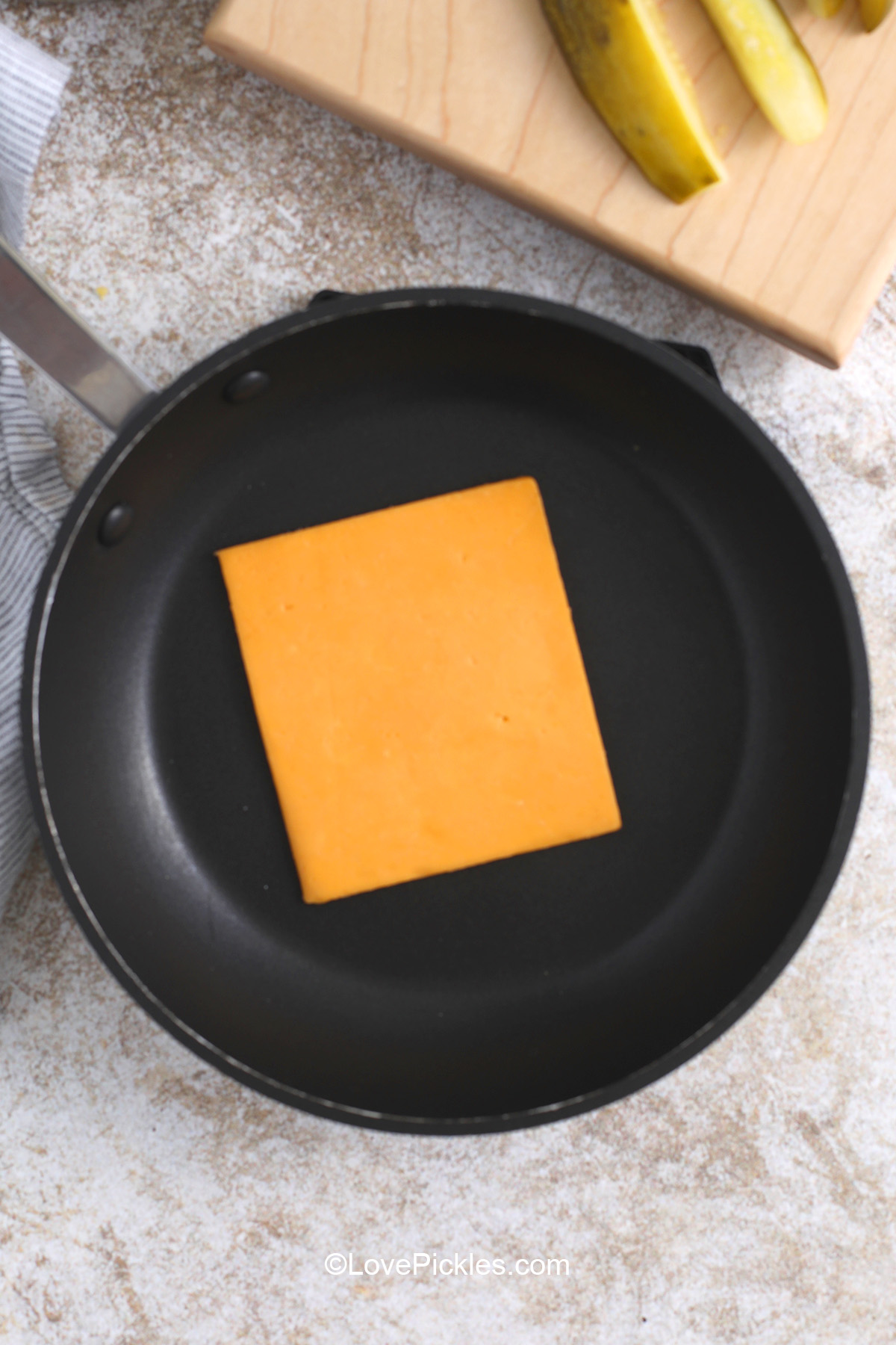 Adding a cheese slice to pan to make chickles.