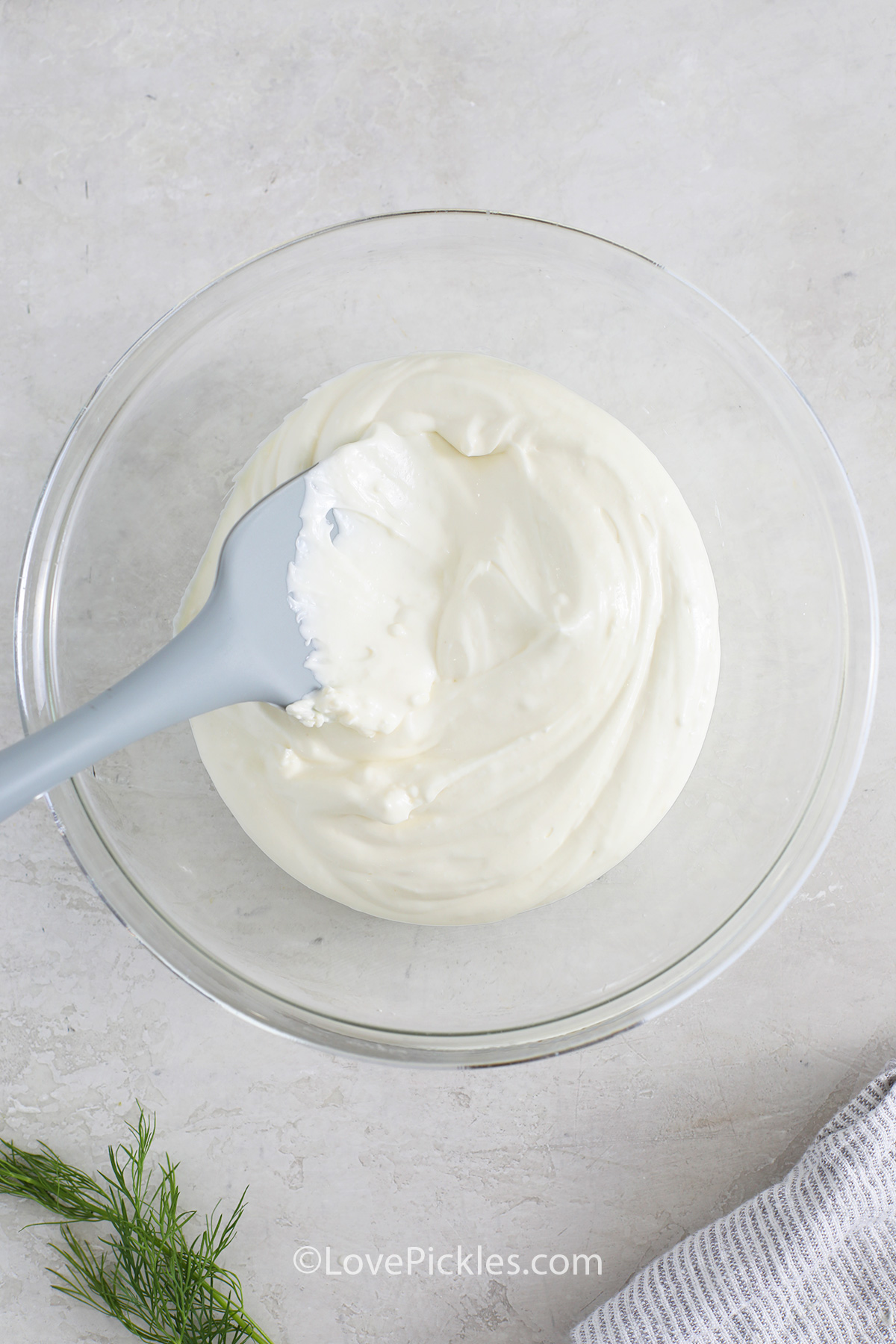Whipping cream cheese in a bowl to make dill pickle dip.