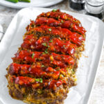 sliced dill pickle meatloaf on a serving platter.