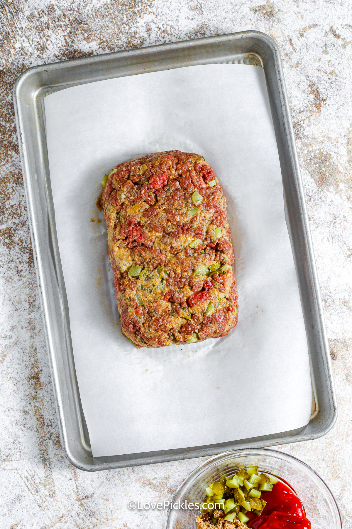 uncooked dill pickle meatloaf on a baking sheet.