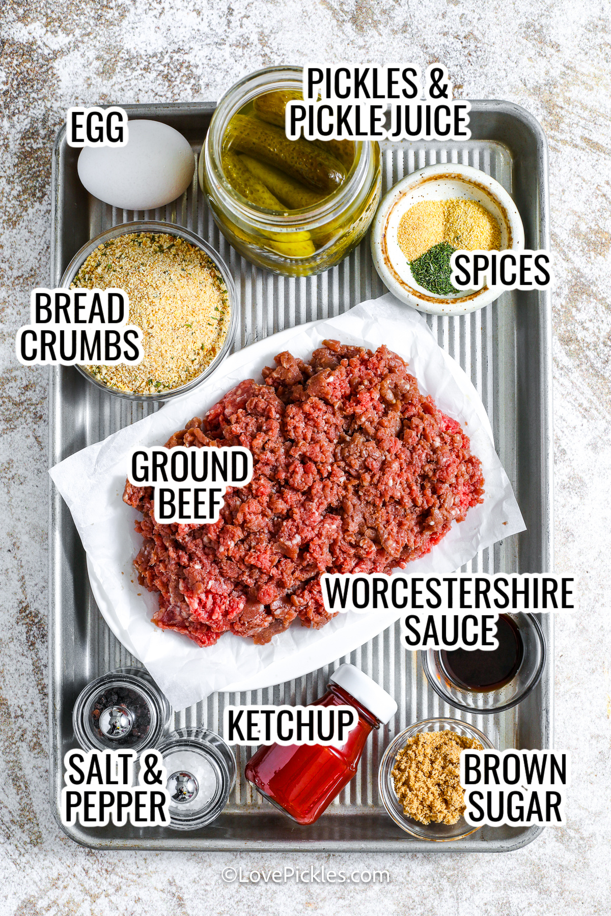 ingredients assembled to make dill pickle meatloaf including ground beef, pickles and pickle juice, bread crumbs, worcestershire sauce, brown sugar, ketchup, egg, spices, and salt and pepper