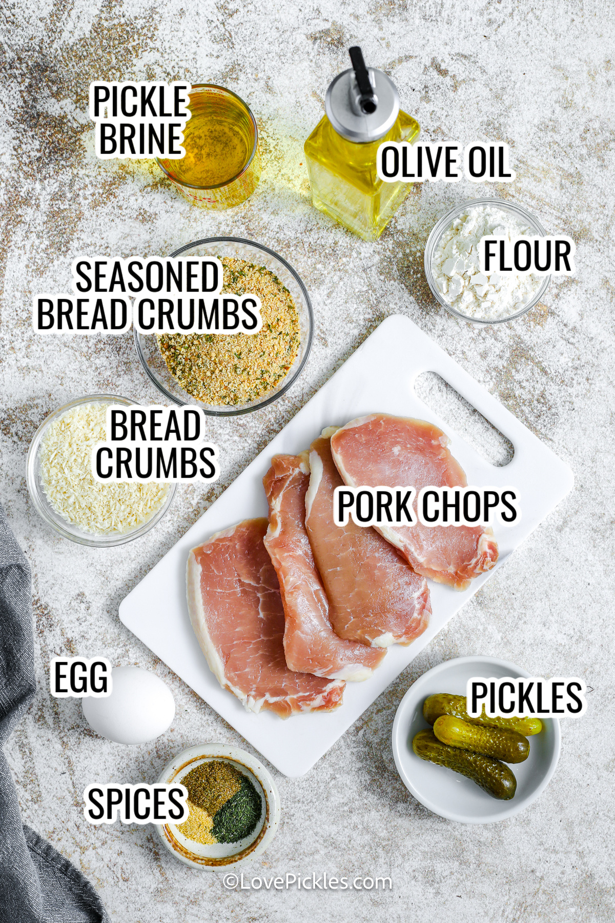 ingredients for dill pickle schnitzel, including pork chops, flour, seasoned bread crumbs, panko bread crumbs, egg, spices, pickles and olive oil