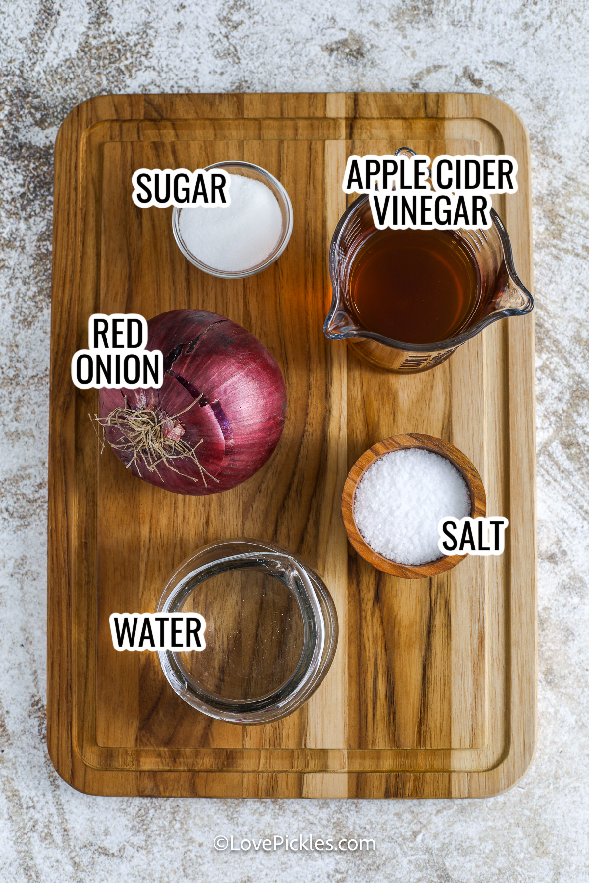 ingredients assembled to make pickled red onions including red onion, apple cider vinegar, salt, sugar, and water