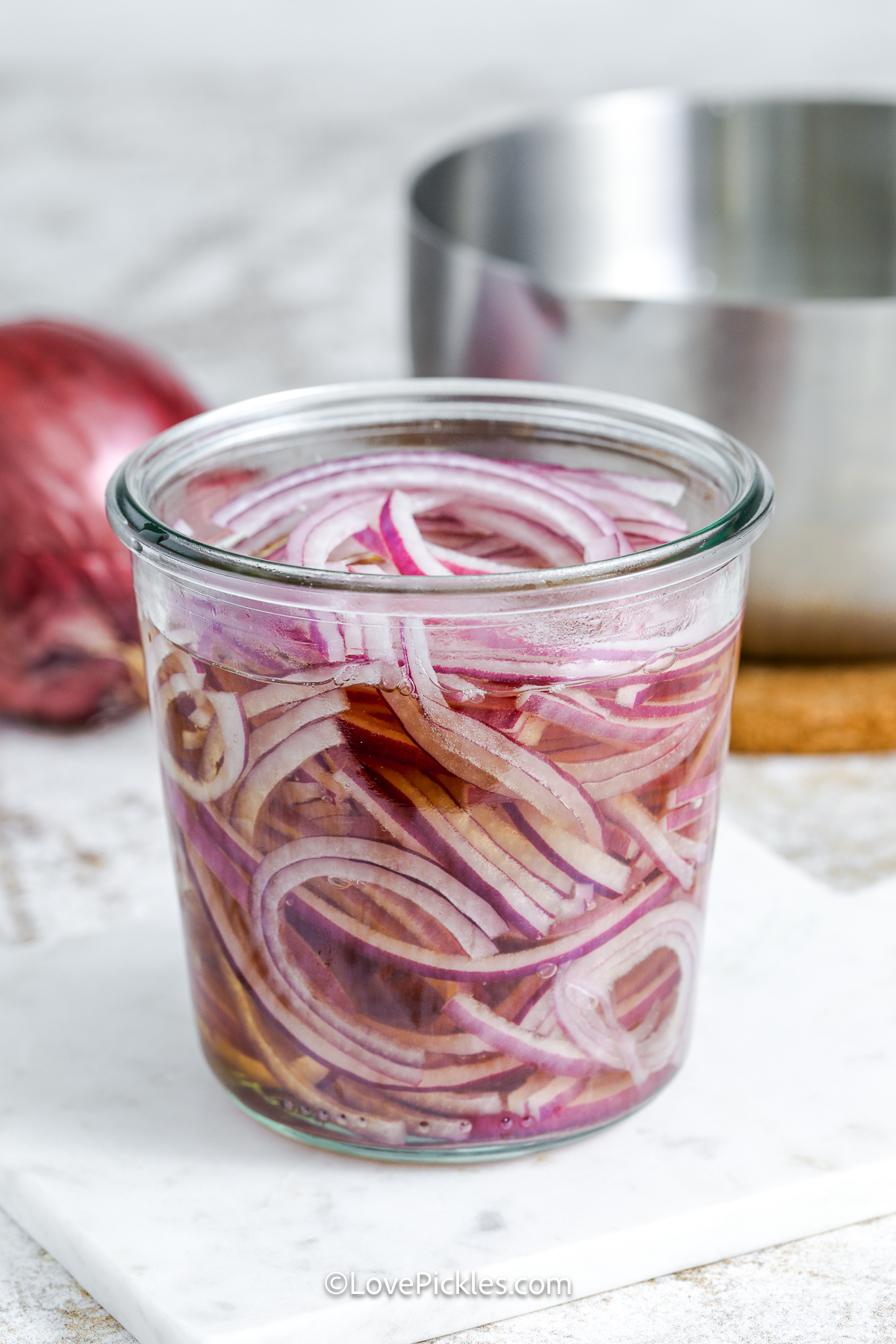 sliced onions and brine in a jar.