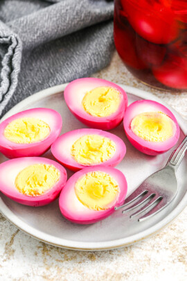beet pickled eggs on a plate with a fork