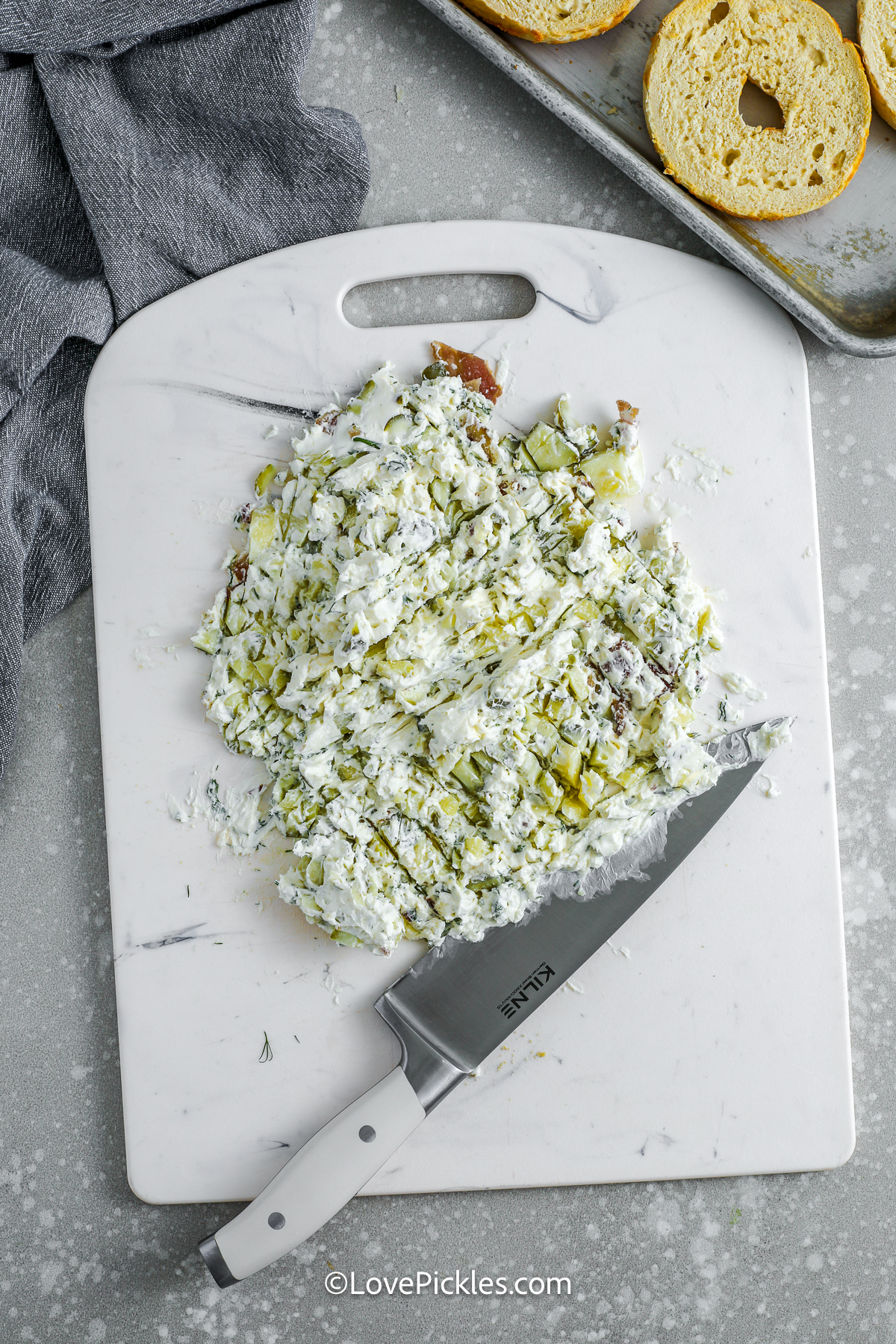 ingredients to make dill pickle cream cheese mixed on a cutting board
