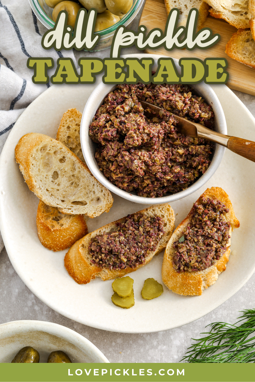 This dill pickle tapenade combines briny olives, tangy dill pickles, and salty capers for a bold and flavorful spread. Blended with garlic, anchovy, olive oil, and fresh lemon juice, it delivers a perfect balance of savory, tangy, and bright flavors. Easy to make in minutes with a food processor, this versatile tapenade is great on crostini or French bread for appetizers, or as a zesty topping on sandwiches and wraps. #lovepickles dill pickle tapenade recipe with text