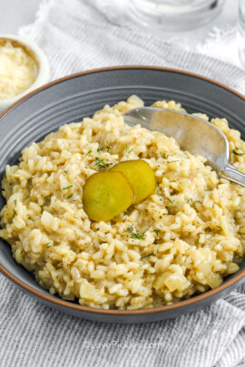 A bowl of dill risotto with a spoon.
