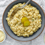 bowl of dill risotto garnished with pickle slices