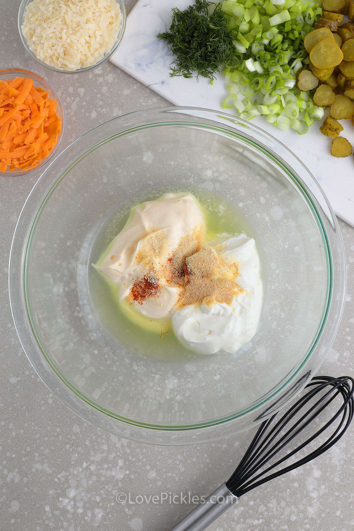 ingredients to make the dressing for tater tot pickle salad being combined in a bowl