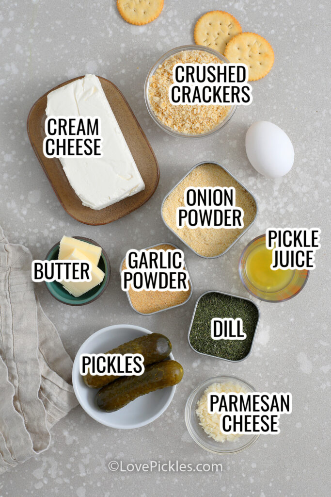ingredients for savory dill pickle cheesecake appetizers, including cream cheese, crushed crackers, onion powder, pickle juice, butter, garlic powder, pickles, parmesan cheese, and dill