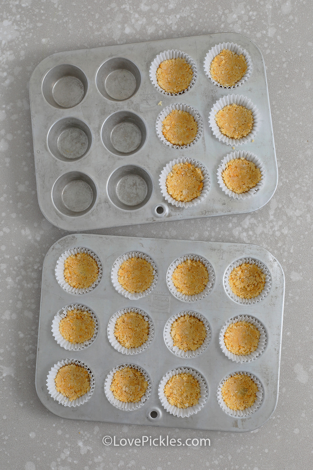 crushed crackers in mini muffin tins for making pickle cheesecake appetizers