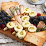 savory dill pickle cheesecake appetizers on a charcuterie board