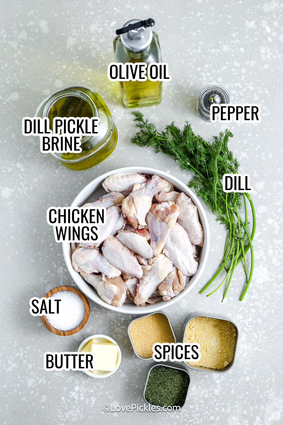 ingredients for dill pickle chicken wings, including dill pickle brine, olive oil, pepper, salt, chicken wings, butter, dill, spices